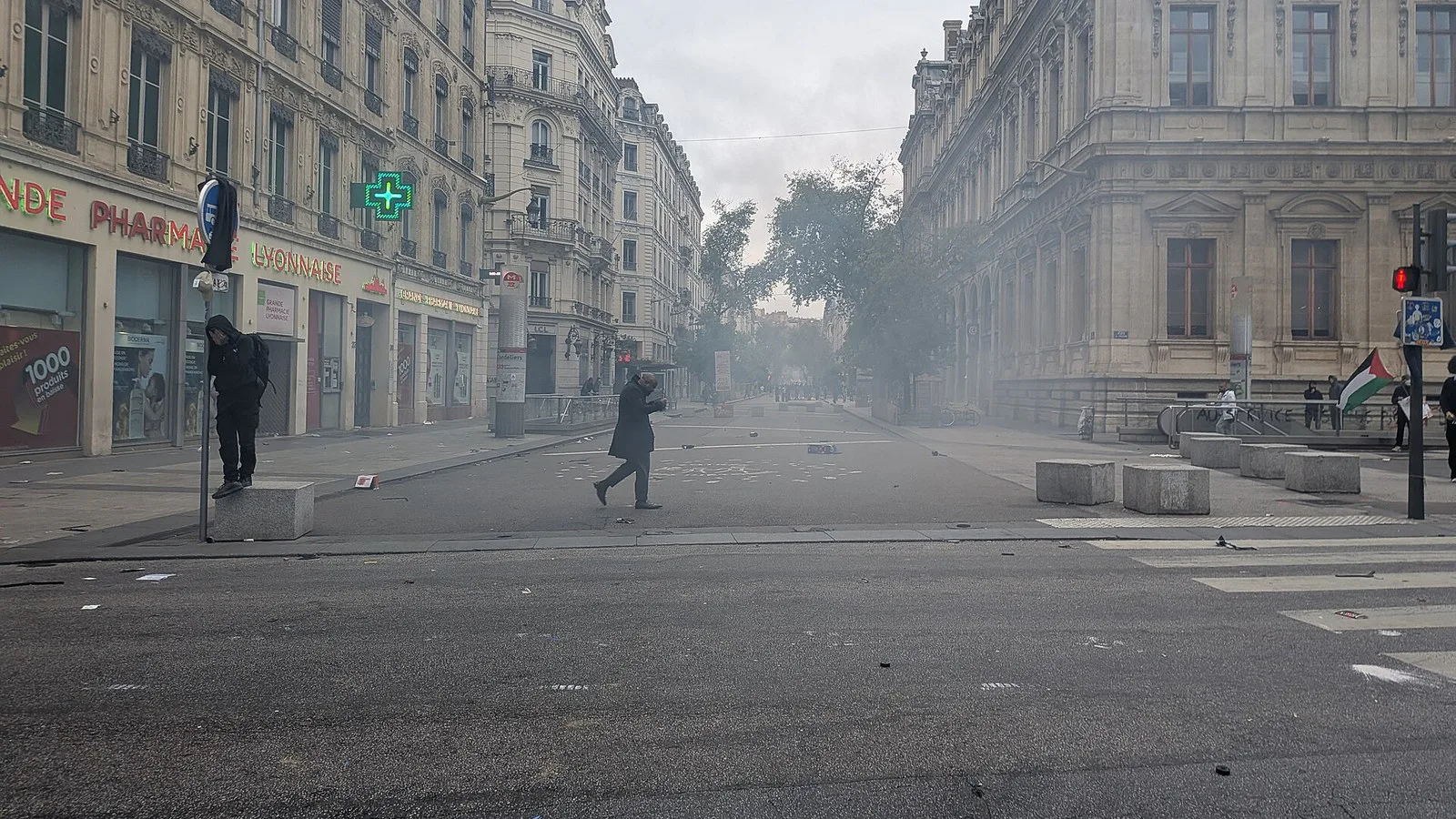 Rua da República, em Lyon, tomada por gás lacrimogêneo durante os atos de 17 de outubro de 2026, com poucas pessoas caminhando