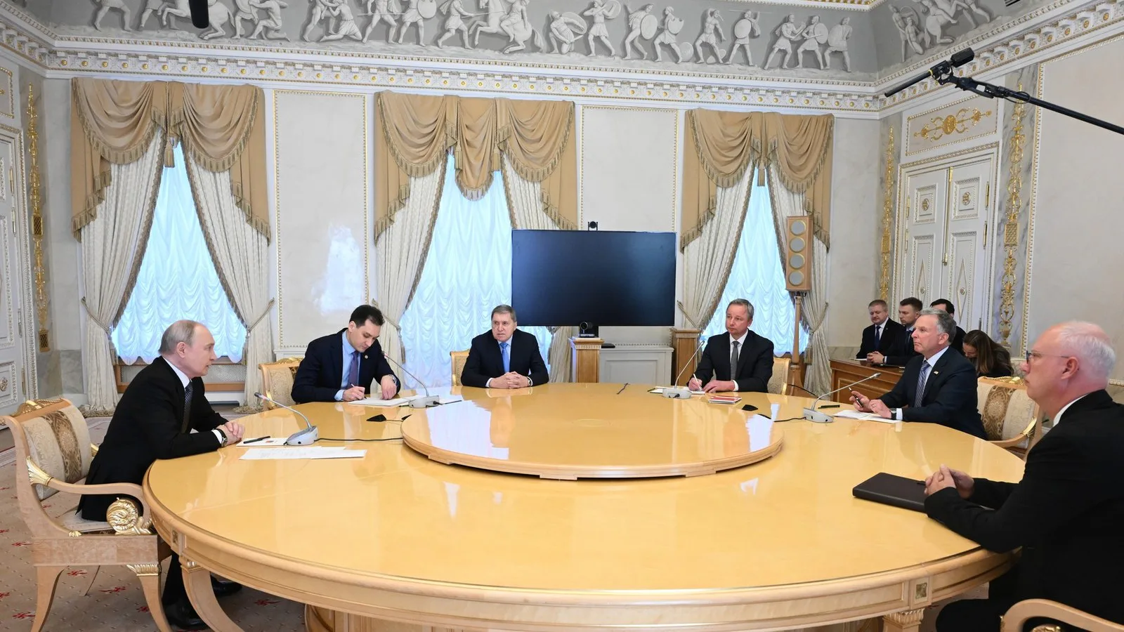 Vladimir Putin, à esquerda, e participantes da reunião com Steve Witkoff em volta de uma mesa redonda no Palácio Konstantinovsky, em São Petersburgo, em 21 de outubro de 2026