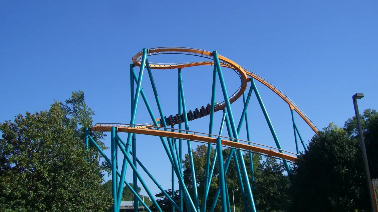Estrutura em hélice do Goliath, com trilhos laranja e pilares verdes, no parque Six Flags Over Georgia