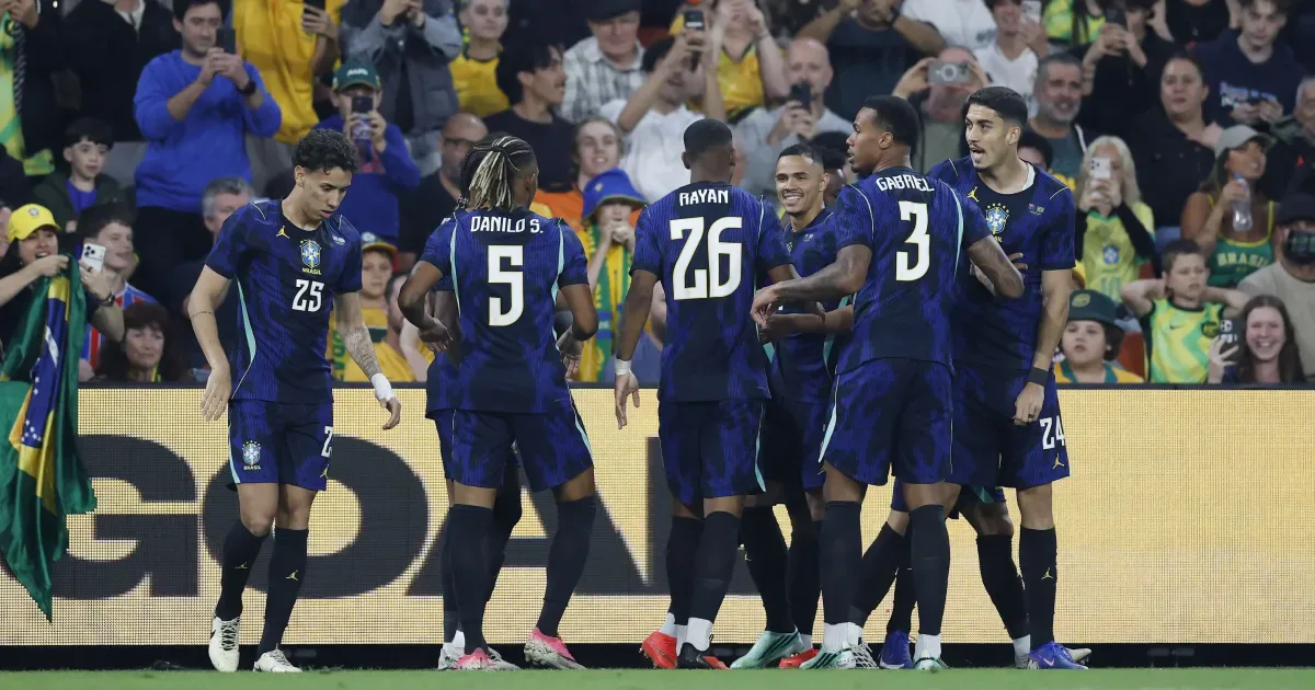 Jogadores da seleção brasileira comemoram durante partida contra a Austrália em estádio lotado com torcedores assistindo das arquibancadas