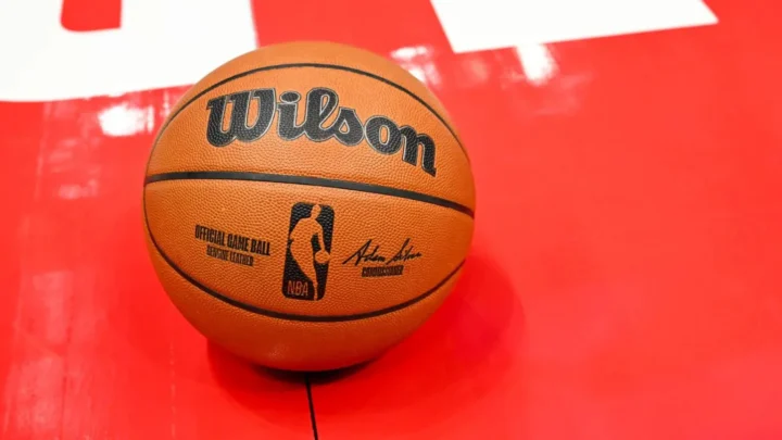 Bola oficial da NBA com tecnologia integrada para coleta de dados em tempo real, posicionada sobre quadra vermelha