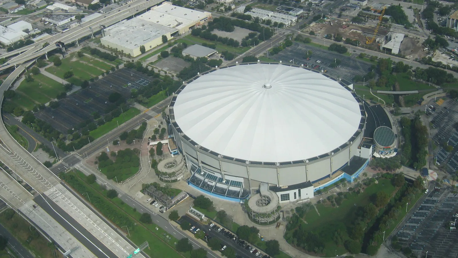 Vista aérea da cúpula branca do Tropicana Field, em St. Petersburg, cercada por estacionamentos e avenidas