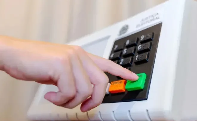 Eleitor aciona equipamento de votação eletrônica. A Casa Branca afirmou que não enviará agentes do ICE para patrulhar os locais de votação na Flórida, onde brasileiros votam neste domingo (4) nas Eleições 2026.