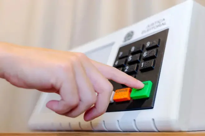 Eleitor aciona equipamento de votação eletrônica. A Casa Branca afirmou que não enviará agentes do ICE para patrulhar os locais de votação na Flórida, onde brasileiros votam neste domingo (4) nas Eleições 2026.