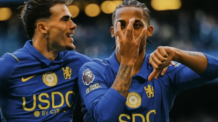 Jogadores de camisa azul com patrocínio USDC comemoram gol, um deles fazendo gesto com as mãos diante do rosto