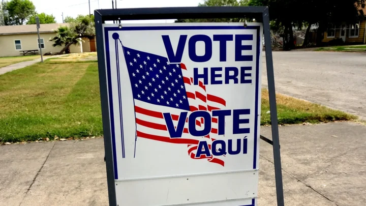 Placa bilíngue "Vote Here / Vote Aquí", com a bandeira dos Estados Unidos, sobre uma calçada em Taft, no Texas, em outubro de 2016 (imagem ilustrativa)