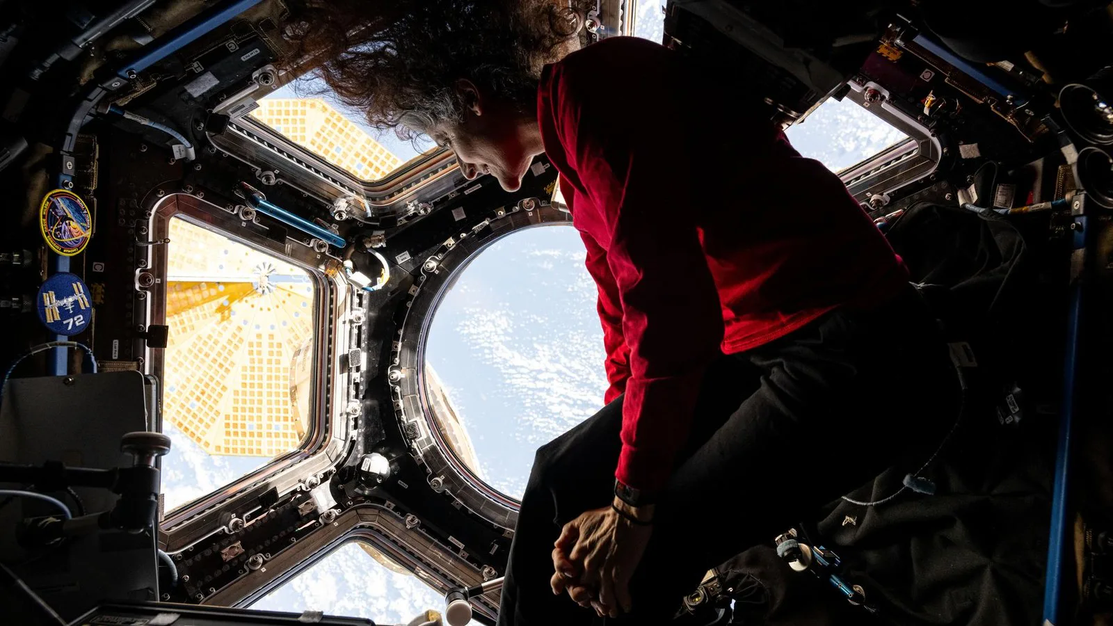 A astronauta Suni Williams olha a Terra pelas janelas da Cúpula, o módulo de observação da Estação Espacial, em março de 2025