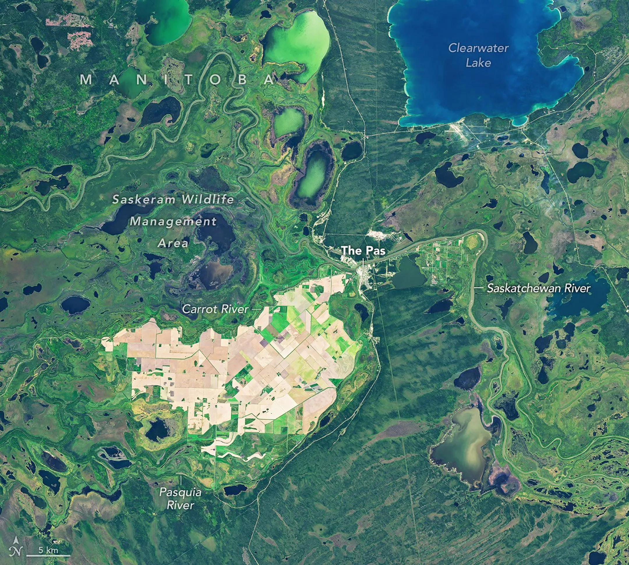 A mesma área no outono mostra que muitos dos campos agrícolas agora estão marrons, e as áreas úmidas ao redor têm menos água.
