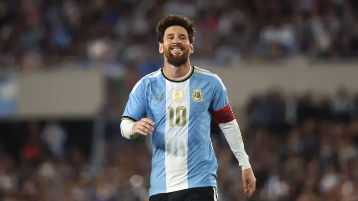 Jogador com camisa listrada azul e branca número 10 corre em campo durante partida de futebol com público ao fundo