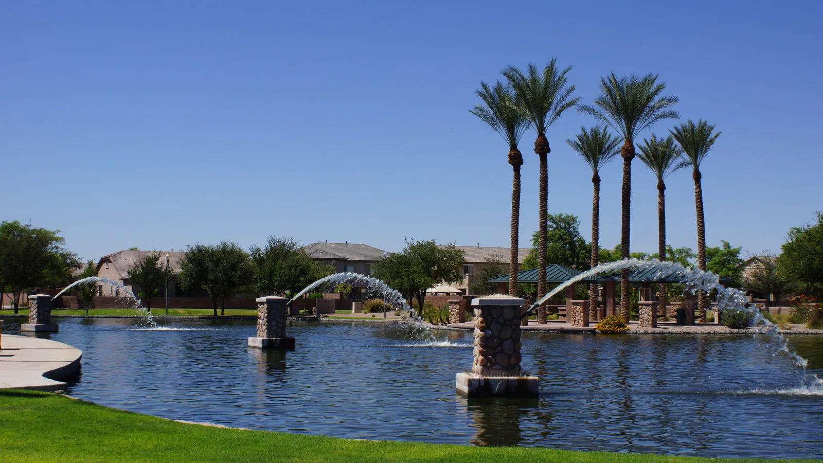 Foto de arquivo de 2014 feita em Maricopa, no Arizona: lago com chafarizes e palmeiras diante de casas