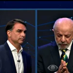 Tela dividida da transmissão: Flávio Bolsonaro à esquerda e Lula à direita, durante a pergunta sobre os Estados Unidos