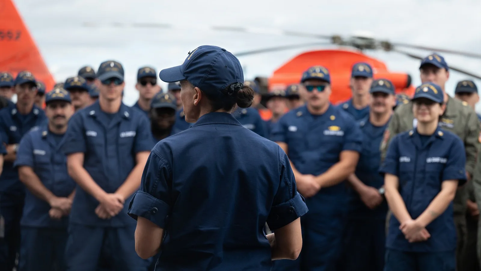 A vice-almirante Jo-Ann Burdian, de costas, conversa com a tripulação do Tampa depois do desembarque