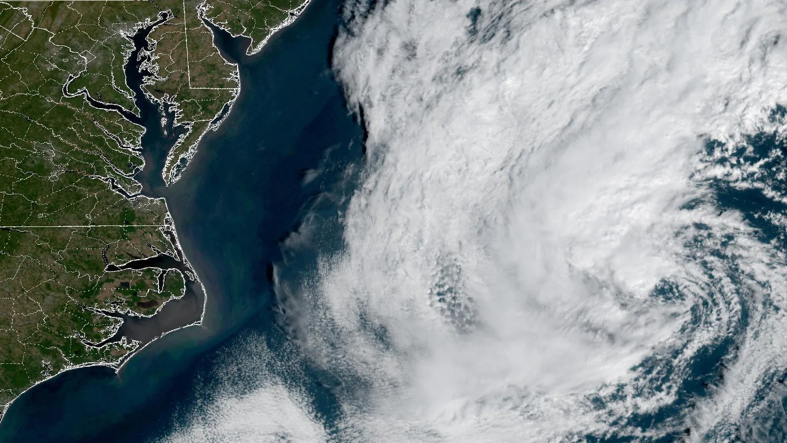 Imagem de satélite mostra a grande massa de nuvens em espiral do sistema de baixa pressão sobre o Atlântico, a leste da costa da Carolina do Norte e do Meio-Atlântico, na manhã de 20 de outubro