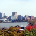 Vista do centro de Evansville, em Indiana, com prédios atrás de um rio e árvores de outono em primeiro plano (foto de arquivo)