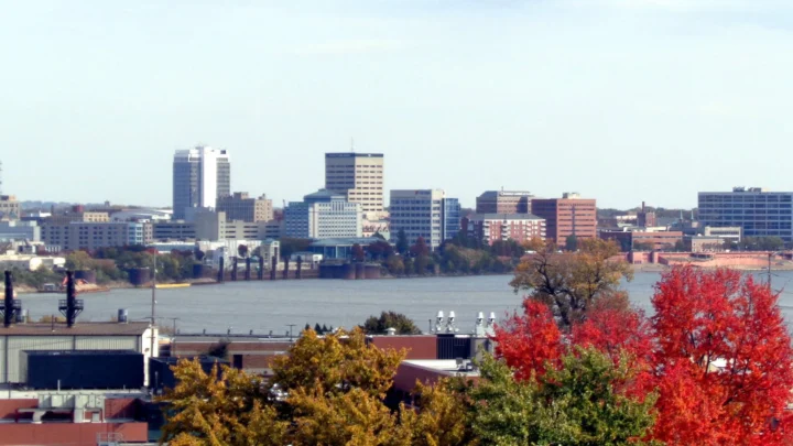 Vista do centro de Evansville, em Indiana, com prédios atrás de um rio e árvores de outono em primeiro plano (foto de arquivo)