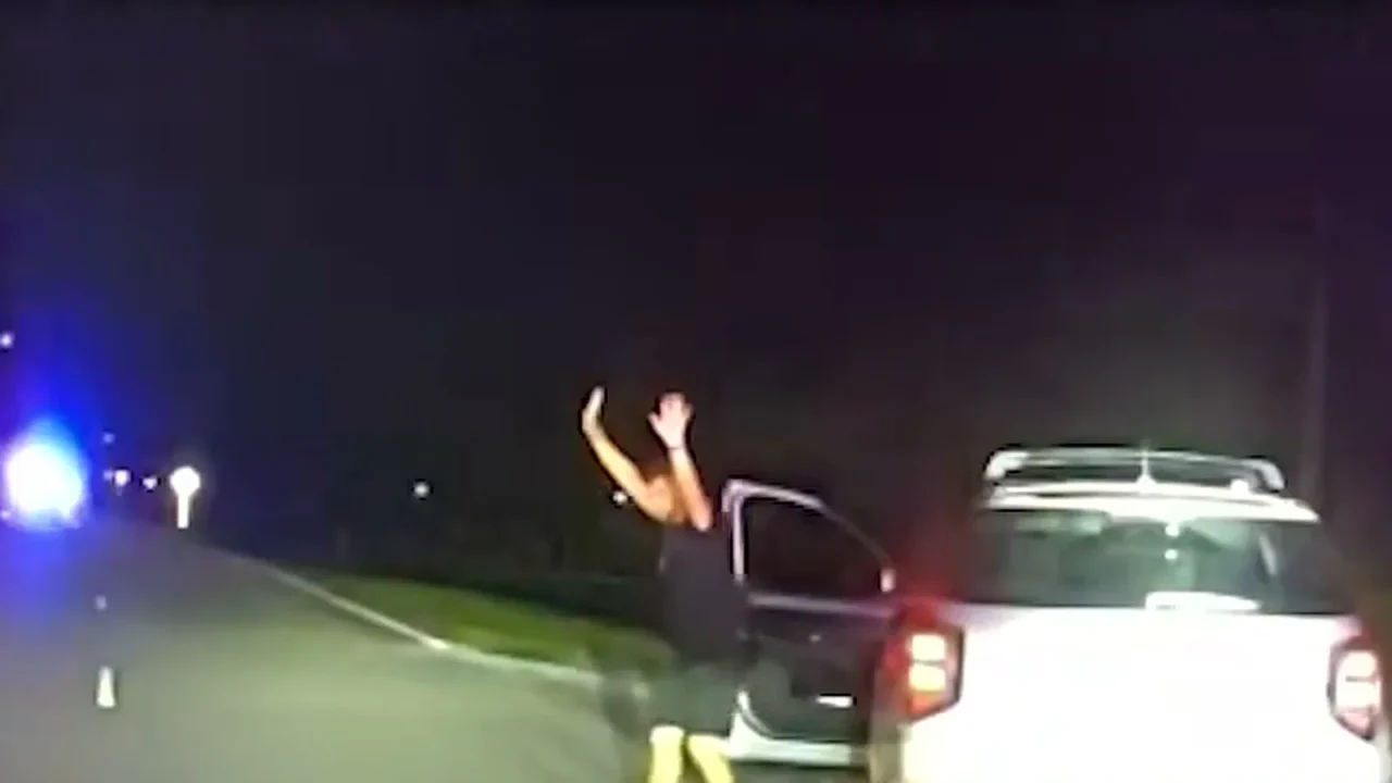 Câmera de viatura mostra o motorista saindo do carro com as mãos para o alto durante a abordagem, à noite, no condado de Pinellas