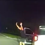 Câmera de viatura mostra o motorista saindo do carro com as mãos para o alto durante a abordagem, à noite, no condado de Pinellas