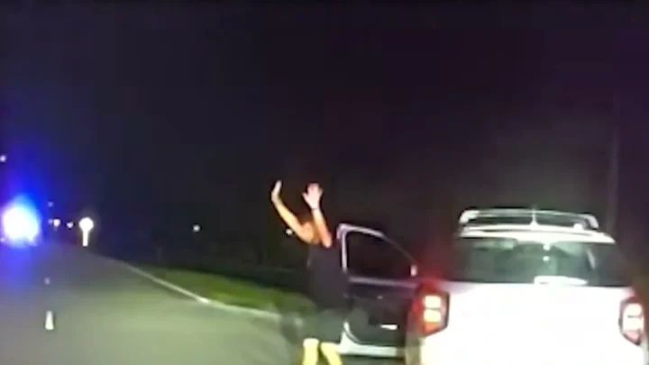 Câmera de viatura mostra o motorista saindo do carro com as mãos para o alto durante a abordagem, à noite, no condado de Pinellas