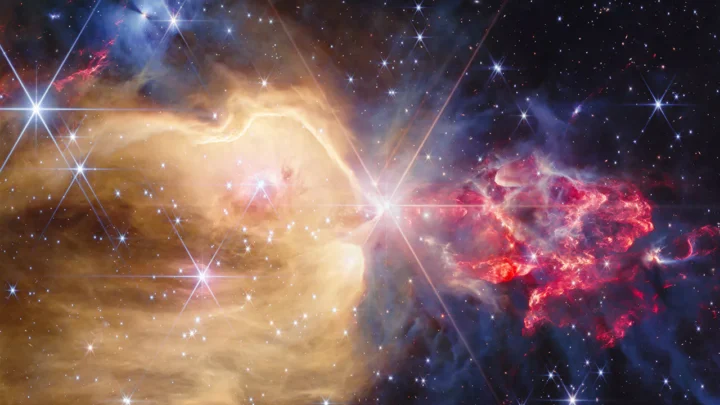 O Telescópio Espacial James Webb da NASA revelou muitas protoestrelas e estrelas dentro dos gases brilhantes de NGC 7129. O gás de hidrogênio atômico quente é mostrado aqui na região dourada, enquanto o gás de hidrogênio molecular mais frio, chocado por protoestrelas embutidas, é representado em