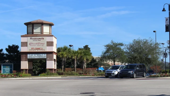 Torre de sinalização do St. Johns Town Center, em Jacksonville, na Flórida, com nomes de restaurantes, palmeiras e carros estacionados ao lado, em foto de arquivo de 2017