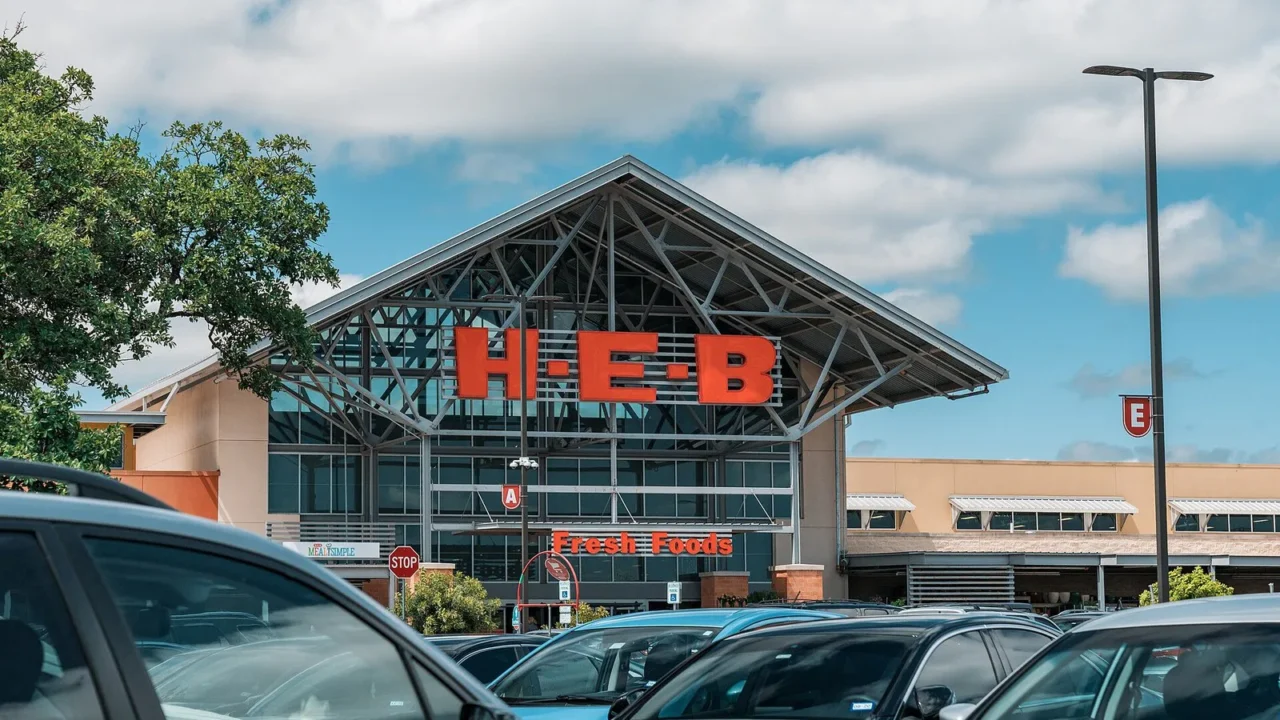 Fachada de uma loja da rede H-E-B com letreiro vermelho e carros estacionados em frente, em Round Rock, no Texas