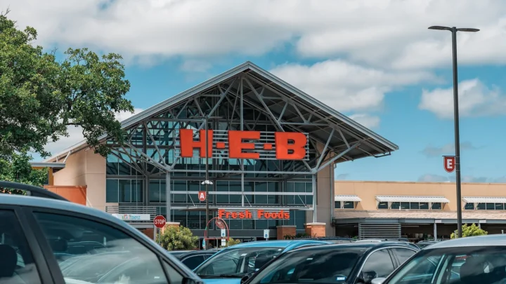 Fachada de uma loja da rede H-E-B com letreiro vermelho e carros estacionados em frente, em Round Rock, no Texas
