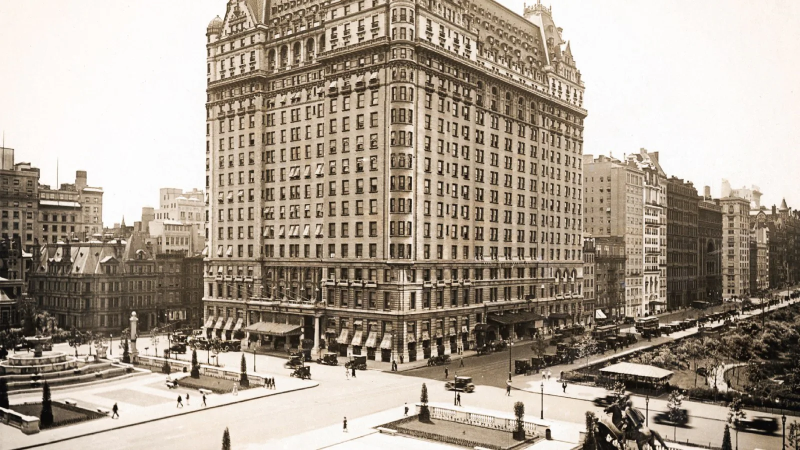 Foto em sépia do Hotel Plaza no início do século 20, com a praça Grand Army Plaza e carros antigos em frente