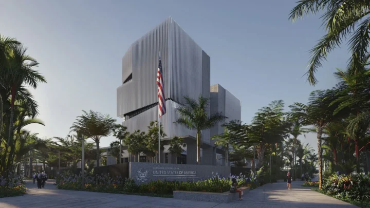 Projeção da entrada do novo Consulado-Geral dos EUA no Rio de Janeiro, com mastro e bandeira americana, palmeiras e o prédio de fachada metálica ao fundo