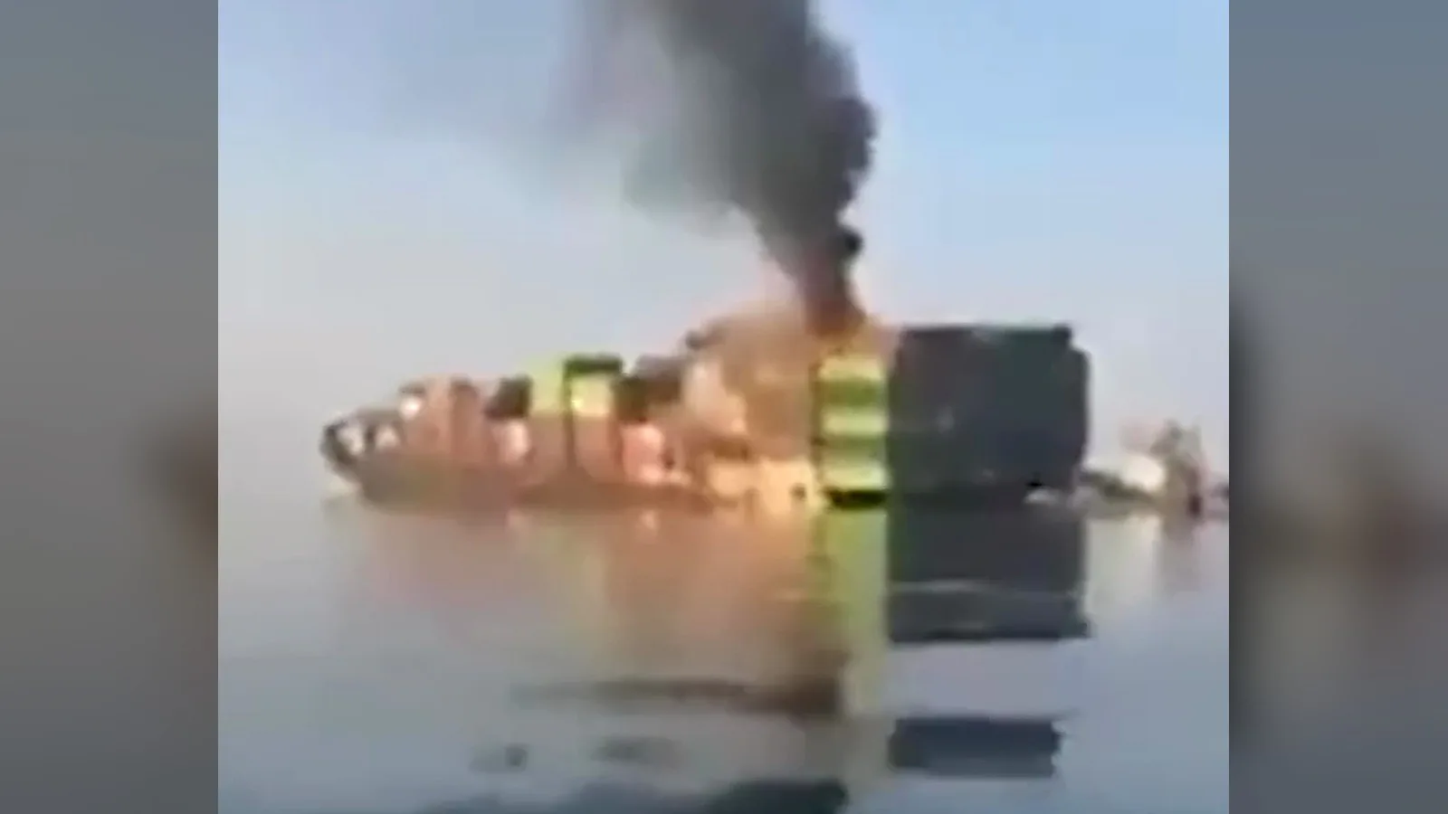 Navio porta-contêineres GFS Pride em chamas, com fumaça preta subindo da pilha de contêineres, no Estreito de Ormuz