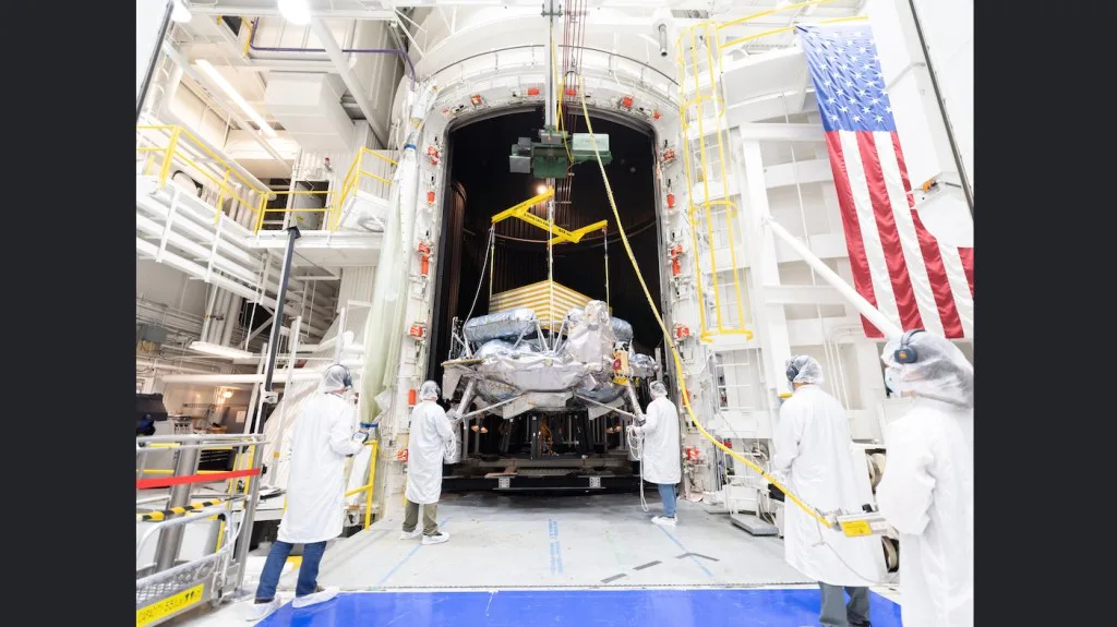 Engenheiros e técnicos usam um guindaste para posicionar o módulo de pouso lunar Griffin-1, da Voyager Technologies, dentro do Simulador Espacial de 25 Pés no Laboratório de Propulsão a Jato da NASA, em 31 de agosto. A espaçonave concluiu recentemente uma série de testes ambientais rigorosos no JPL