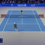 Jogadores disputam um ponto em quadra azul durante partida do ATP 500 em Viena, com placar de 6/6 no set final