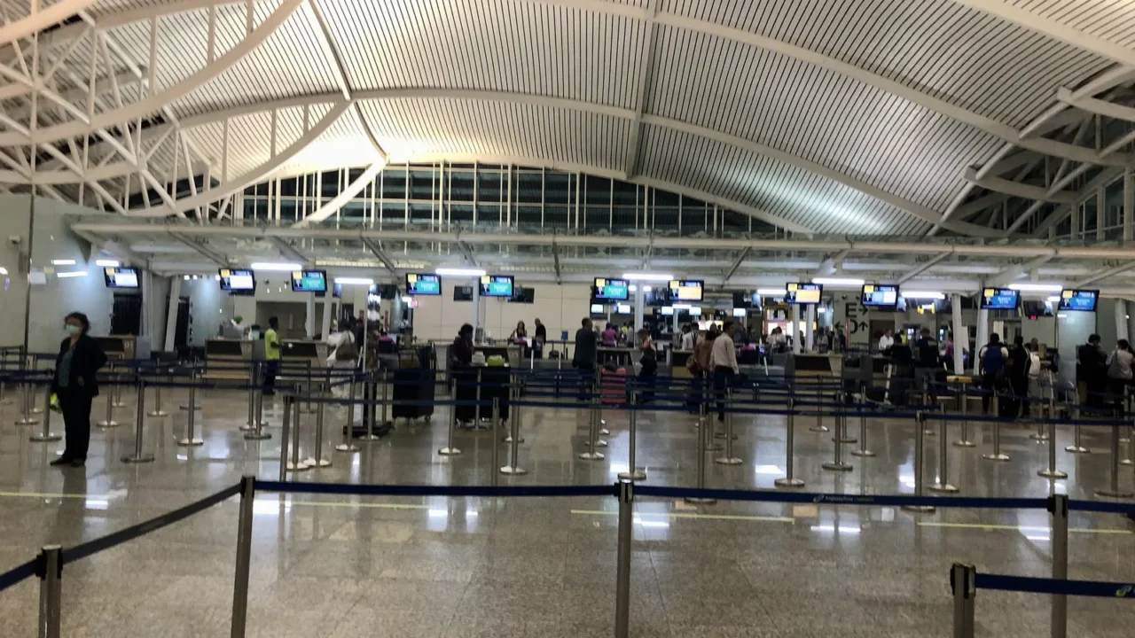 Salão de imigração no desembarque internacional do Aeroporto Internacional I Gusti Ngurah Rai, em Bali, com filas de passageiros diante dos guichês