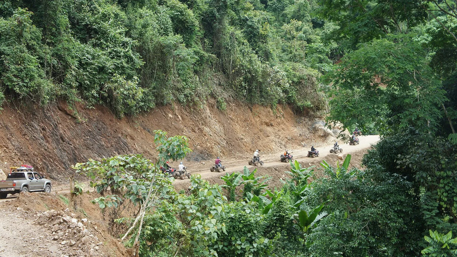 Fila de quadriciclos numa estrada de terra entre a mata, num passeio de aventura no norte da Tailândia, em 2011 (imagem ilustrativa)