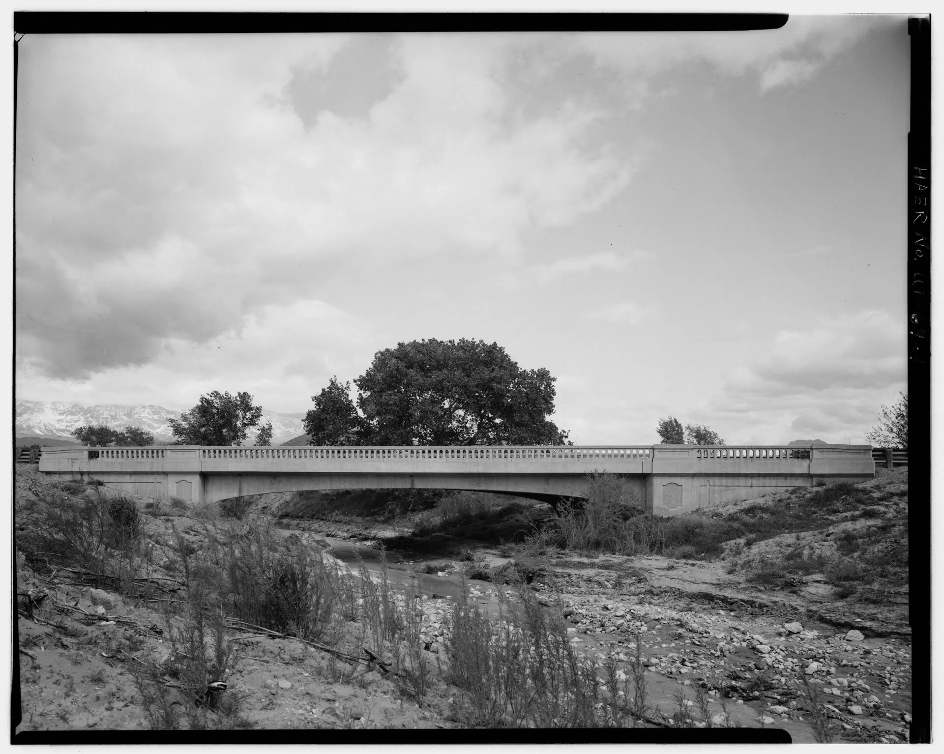 Foto de arquivo em preto e branco: ponte de concreto de 1937 sobre o leito quase seco do Gould Wash, na rodovia estadual 9, em Hurricane, com árvores e montanhas ao fundo