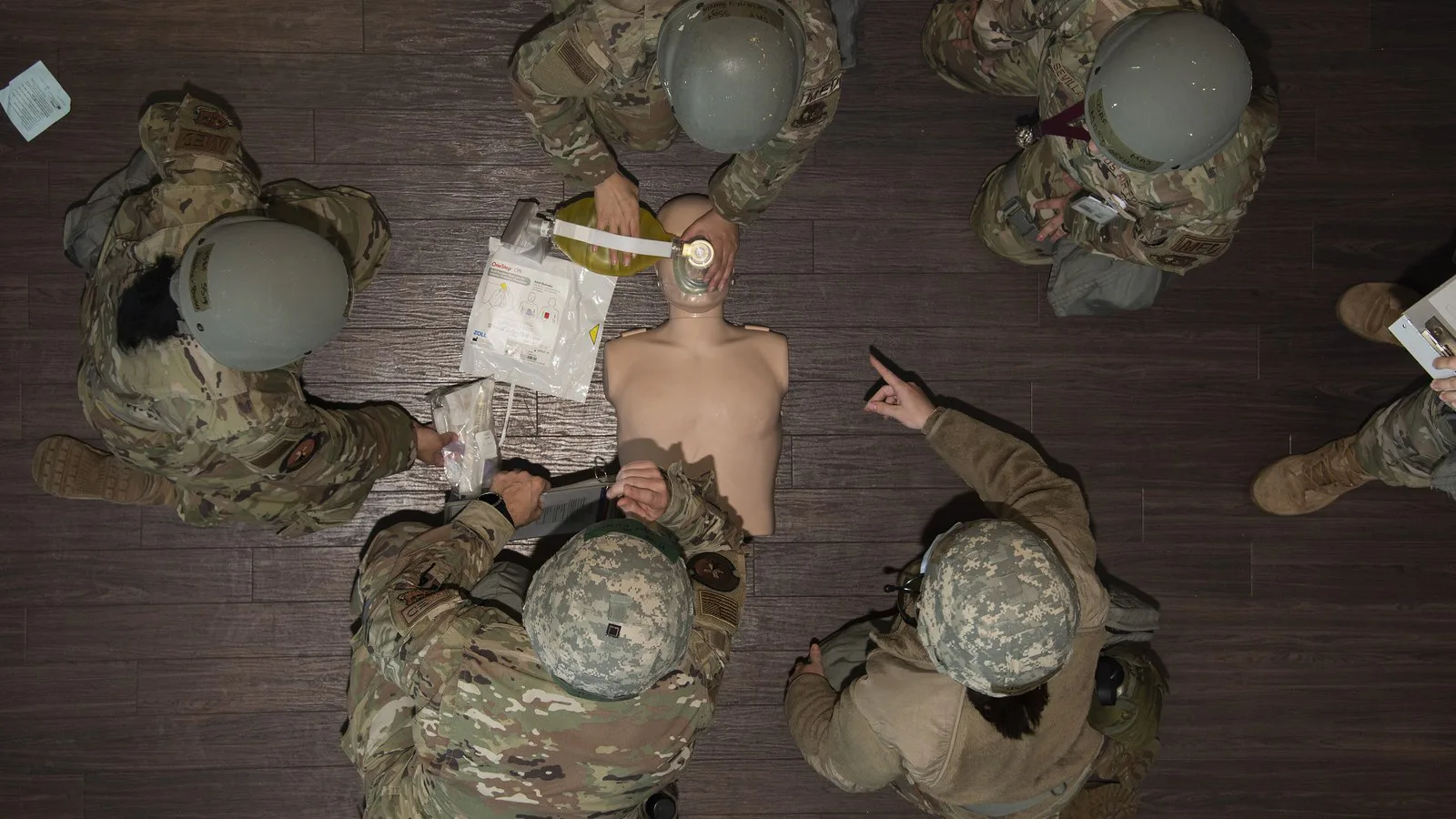 Imagem ilustrativa: militares da Força Aérea dos EUA fazem massagem cardíaca em um boneco de treinamento durante um exercício, vistos de cima