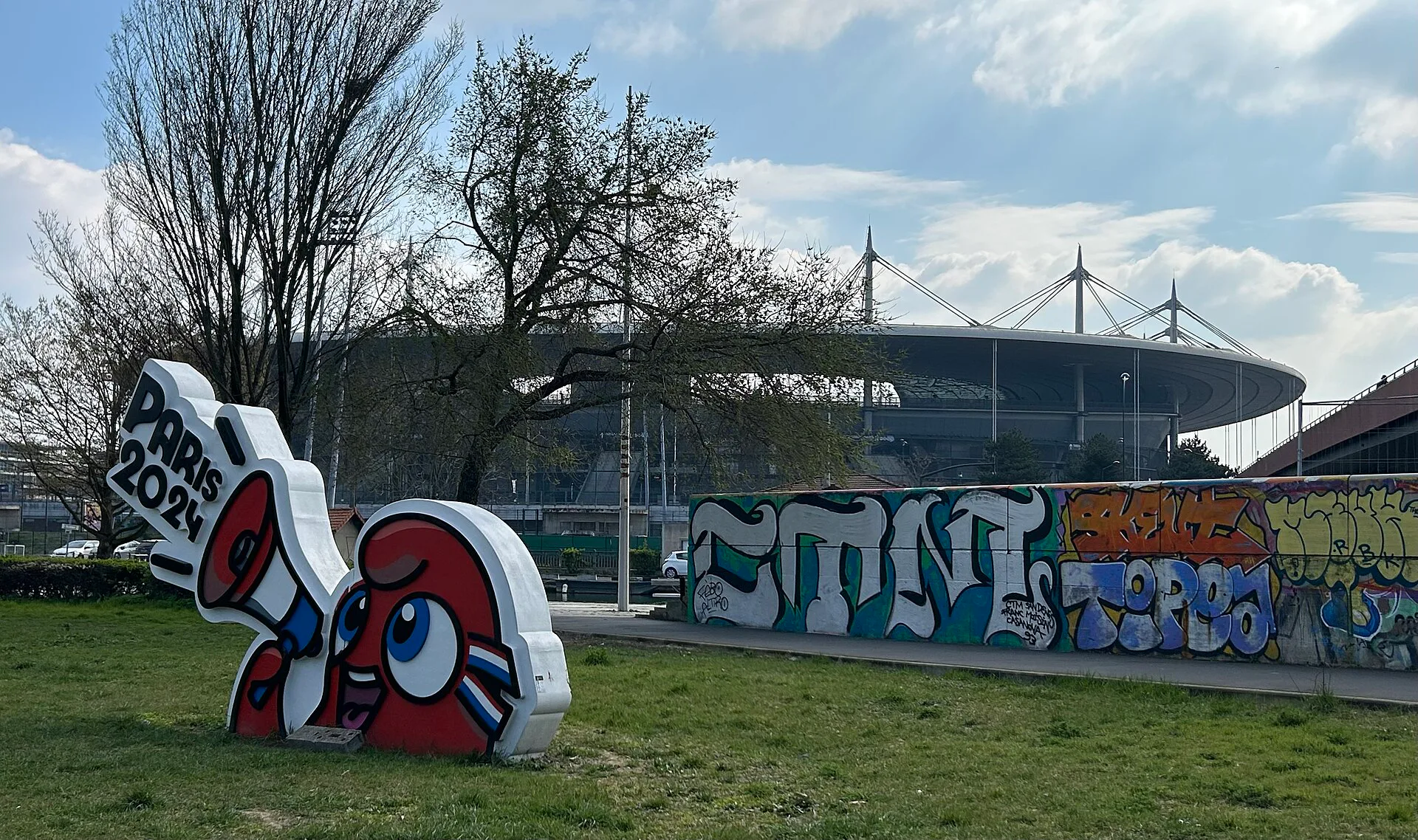 O Stade de France, em Saint-Denis, ao norte de Paris, visto de um jardim próximo, com a cobertura do estádio ao fundo (foto de arquivo, março de 2025)