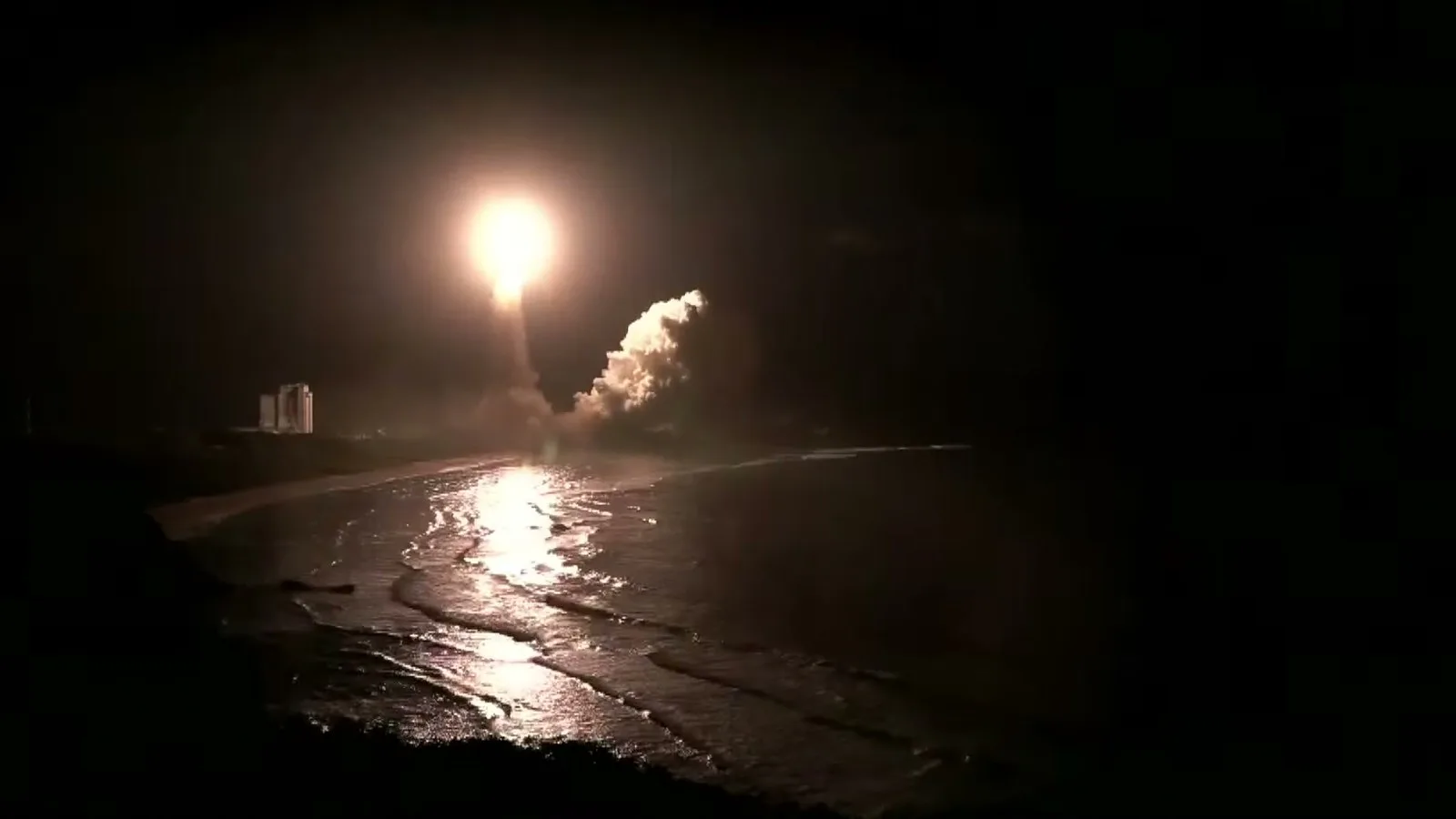 O H3 sobe na escuridão da madrugada, com o clarão refletido no mar e a nuvem de fumaça ao lado da plataforma
