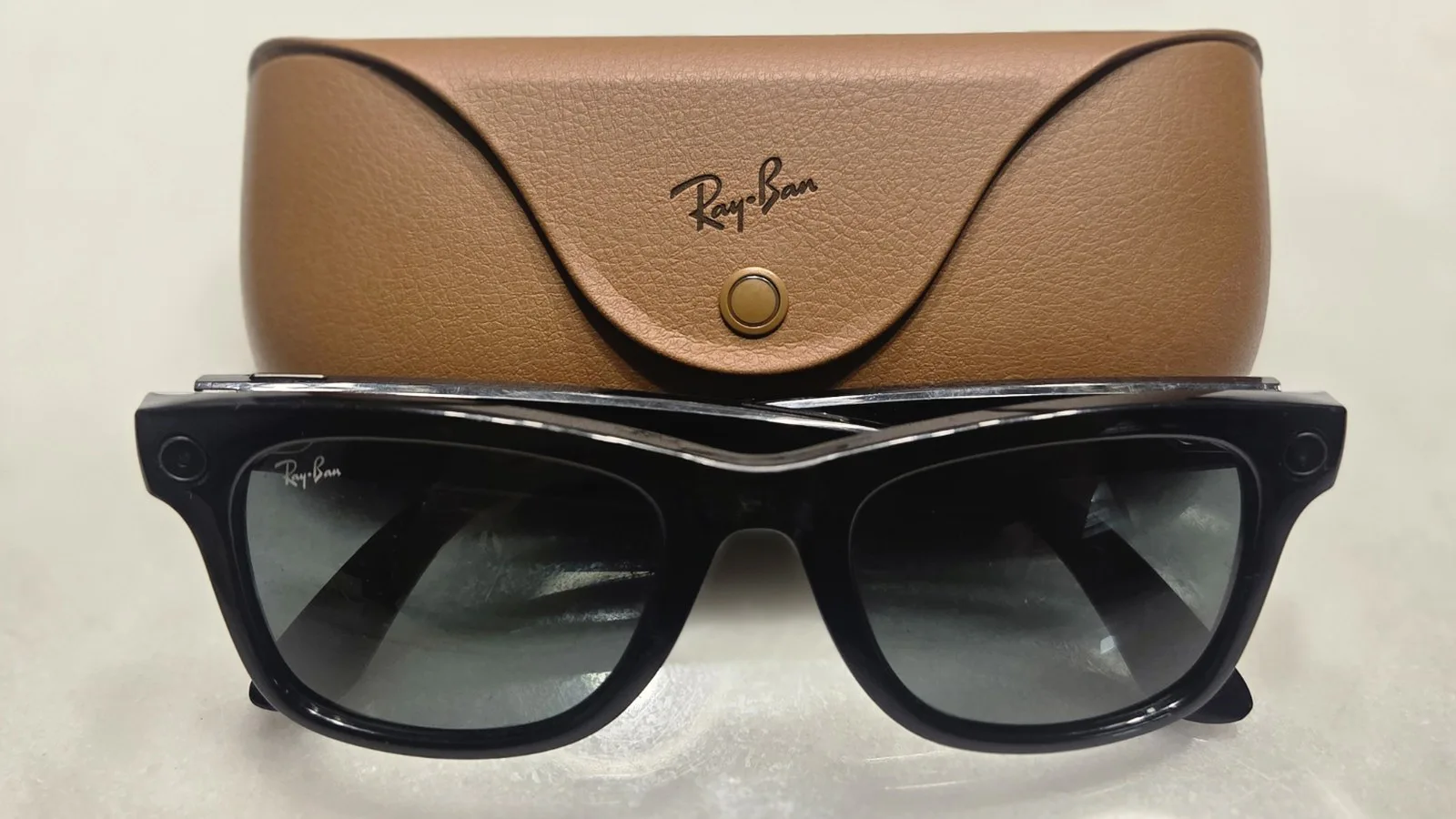 Óculos inteligentes Ray-Ban Meta, de armação preta, na frente do estojo de carregamento marrom; é um modelo sem tela, diferente do Meta Ray-Ban Display (imagem de arquivo)