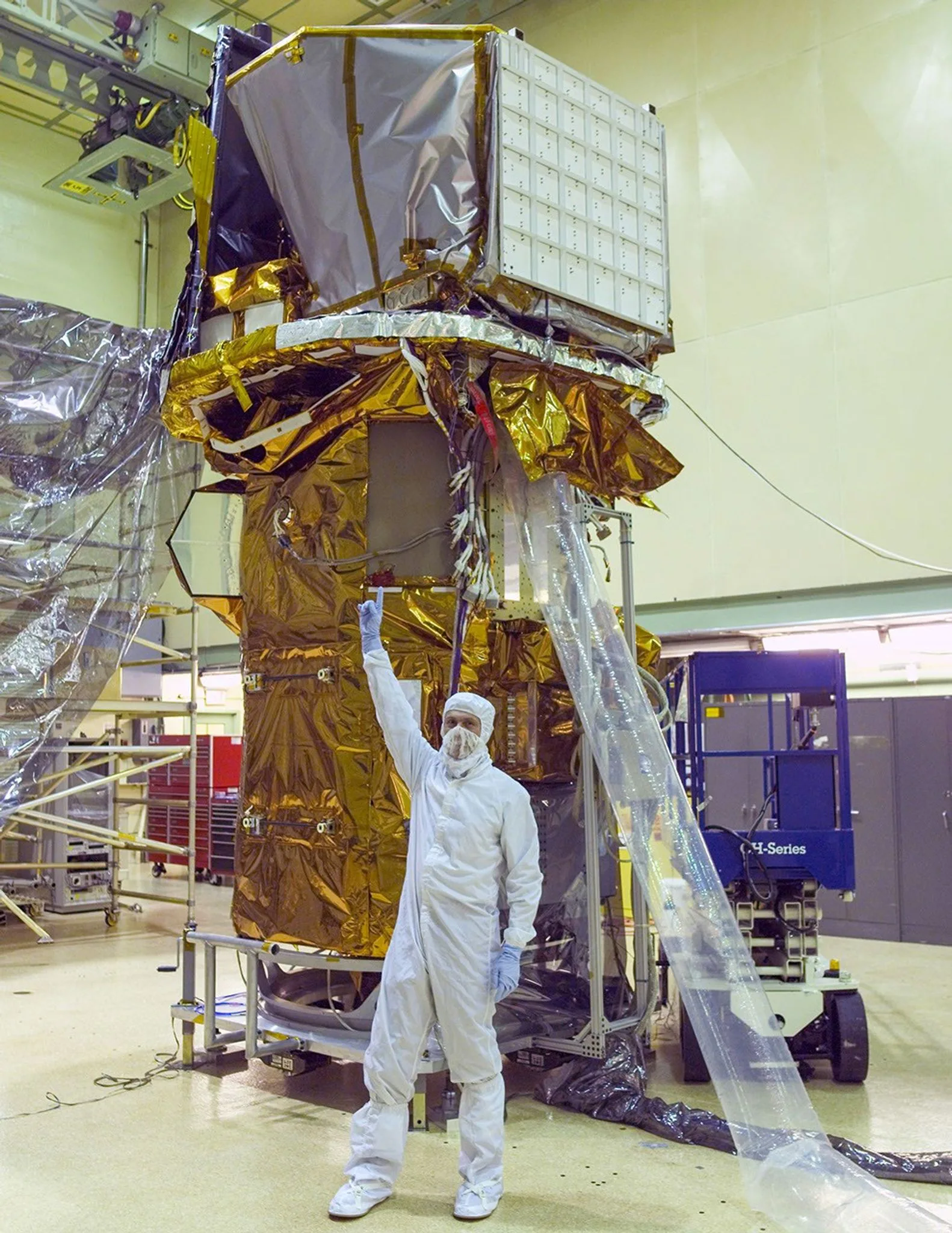 A espaçonave Swift concluída, vista em uma sala limpa no Goddard da NASA em 9 de setembro de 2003. Na frente dela, Neil Gehrels, primeiro pesquisador principal da missão, aponta para os instrumentos no topo.