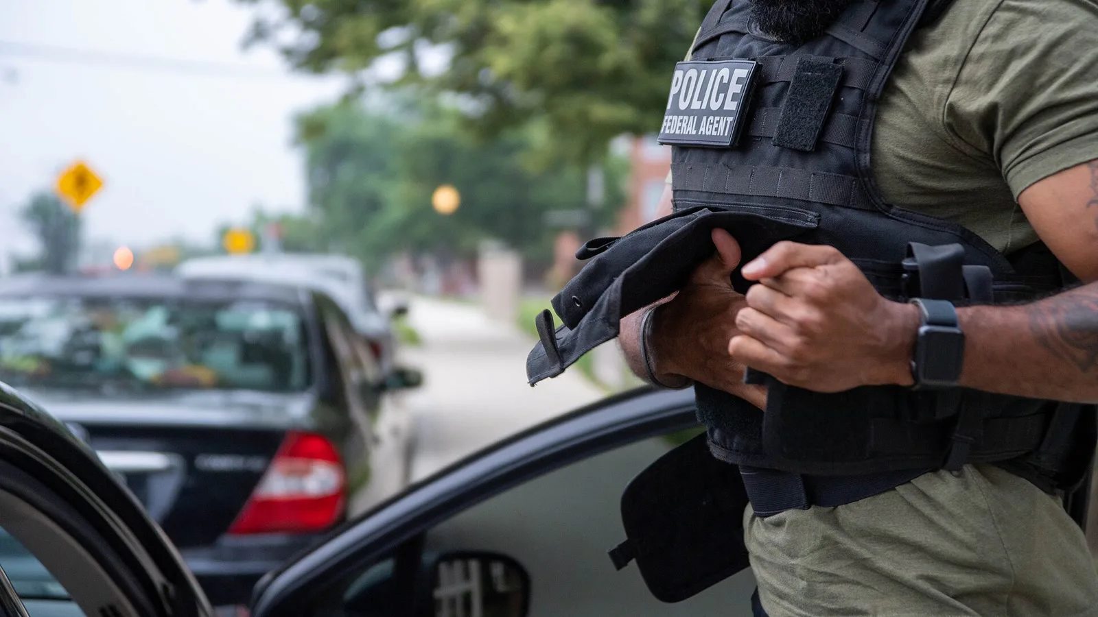 Agente federal ajusta colete com a inscrição "POLICE" durante operação do ICE em Maryland, em junho de 2022 (imagem de arquivo; o órgão que agiu em Newark não foi confirmado)