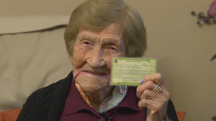 Carmelina Alves Nogueira, de 106 anos, exibe o título de eleitor neste domingo (4), em São Paulo. Moradora do Jaguaré, na Zona Oeste, ela nasceu antes da criação da Justiça Eleitoral (1932) e fez questão de comparecer às urnas acompanhada da neta, tendo prioridade por ser idosa.