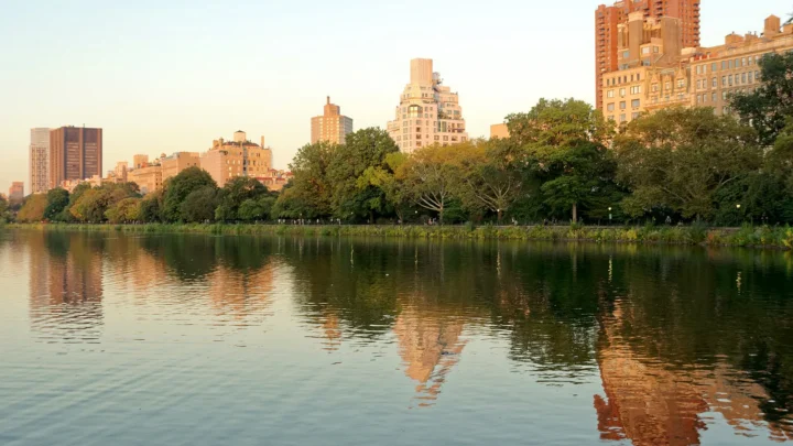 O reservatório Jacqueline Kennedy Onassis, no Central Park, com prédios de Manhattan refletidos na água ao entardecer, em 2023 (imagem de arquivo)
