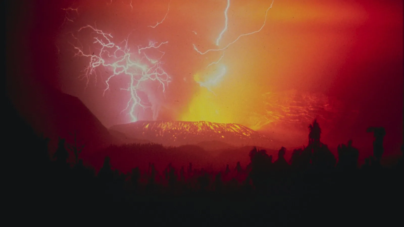 Raios cortam o céu vermelho sobre a cratera do vulcão Galunggung, na Indonésia, durante a erupção de 1982