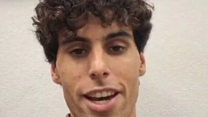 Homem de cabelo cacheado e suéter cinza fala para a câmera, com a legenda "Boas-vindas a Rafael Câmara!" em destaque na tela