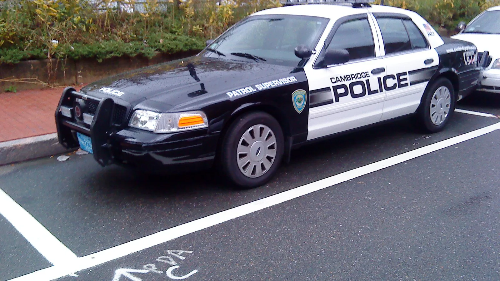 Viatura preta e branca da polícia de Cambridge, em Massachusetts, estacionada junto à calçada (foto de arquivo; não é a polícia que atendeu o caso)