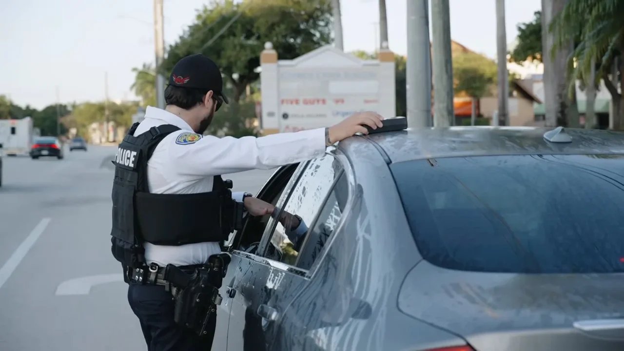 Policial de Fort Lauderdale encosta o medidor de película no vidro lateral de um carro parado numa blitz na North Andrews Avenue