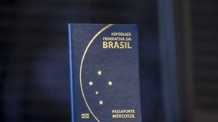 Passaporte brasileiro azul, modelo lançado em 2015, em pé contra um fundo escuro (imagem de arquivo)