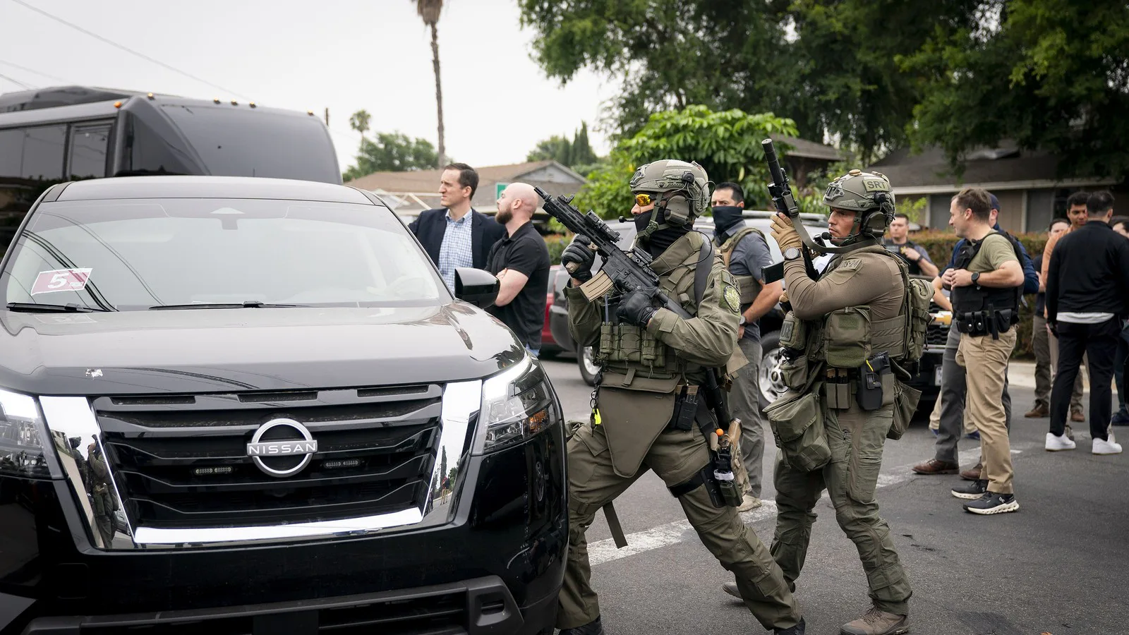 Agentes federais, alguns com uniforme tático e outros à paisana com colete, durante operação do ICE em Los Angeles, em junho de 2025