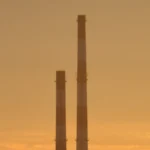 As três chaminés da usina EC-2 contra o céu laranja da tarde em Łódź, na Polônia, em setembro de 2021 (imagem de arquivo)
