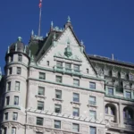 Fachada do Hotel Plaza vista da Quinta Avenida, em Manhattan, com o telhado verde e uma torre arredondada sob céu azul